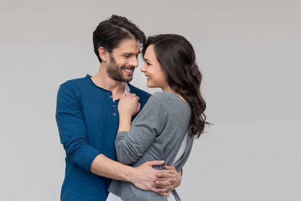 Erectile-Dysfunction-Doctor A man in a blue shirt embracing a woman in a gray shirt smiles due to his successful erectile dysfunction care from Healthy Aging Medical Centers of New Jersey in Northern New Jersey.