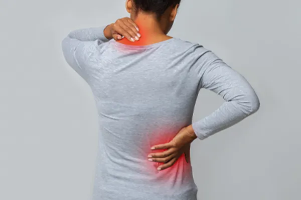 Fibromyalgia-Clinic An image from behind of a woman suffering from Fibromyalgia holding her hands on her neck and lower back. Get fibromyalgia care from Healthy Aging Medical Centers of New Jersey in Northern New Jersey.