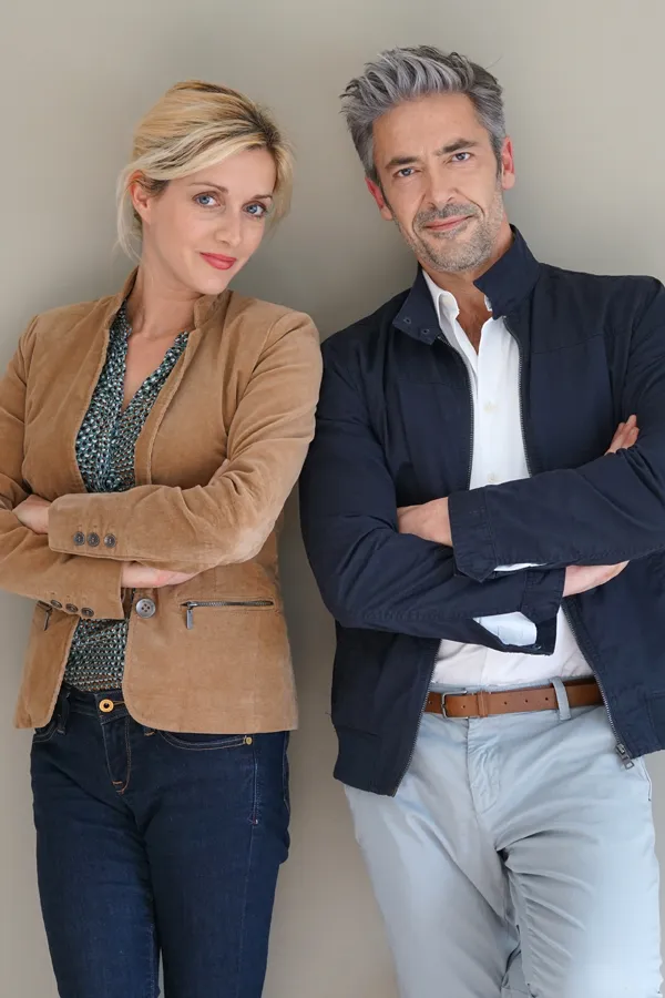 Hyperthyroidism-Treatment A middle-aged couple stand against a wall smiling with folded arms. Get hyperthyroidism treatment from Healthy Aging Medical Centers of New Jersey in Northern New Jersey.