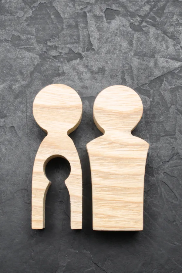 Infertility-Treatment Woodcut figures of a man and woman with a child-shaped area cut out from the woman figure. Get treatment for infertility from Healthy Aging Medical Centers of New Jersey in Northern New Jersey.