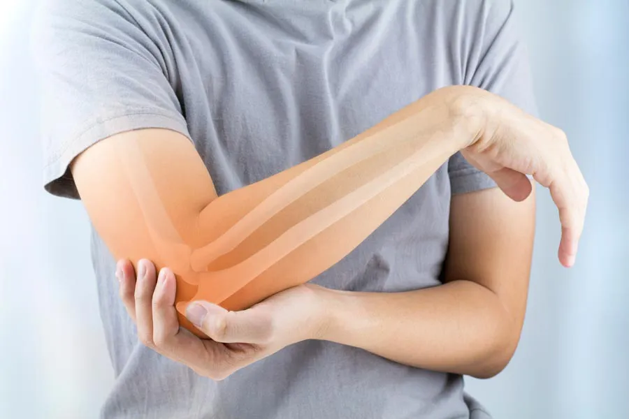 Osteoporosis-Doctor A close-up of a woman holding her elbow with an illustration of the bones and joint experiencing pain from osteoporosis. Get osteoporosis treatment from Healthy Aging Medical Centers of New Jersey in Northern New Jersey.
