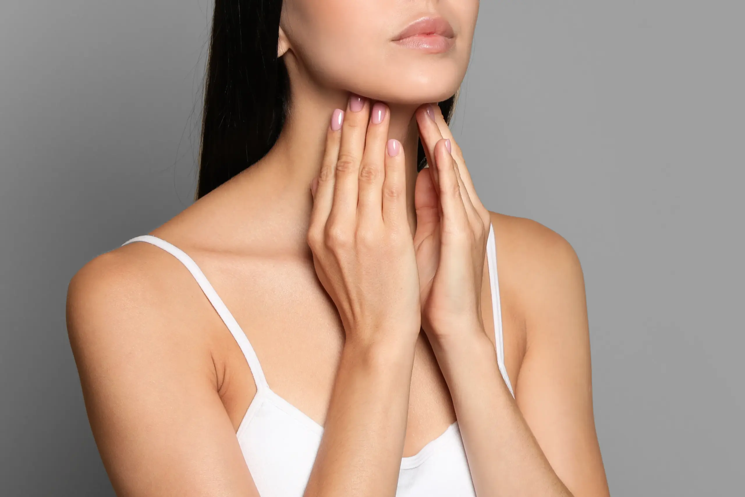 Thyroid-Doctor A woman in a white tank top touches her neck looking for signs of thyroid disorder. Get help for thyroid disorders from Healthy Aging Medical Centers of New Jersey in Northern New Jersey.